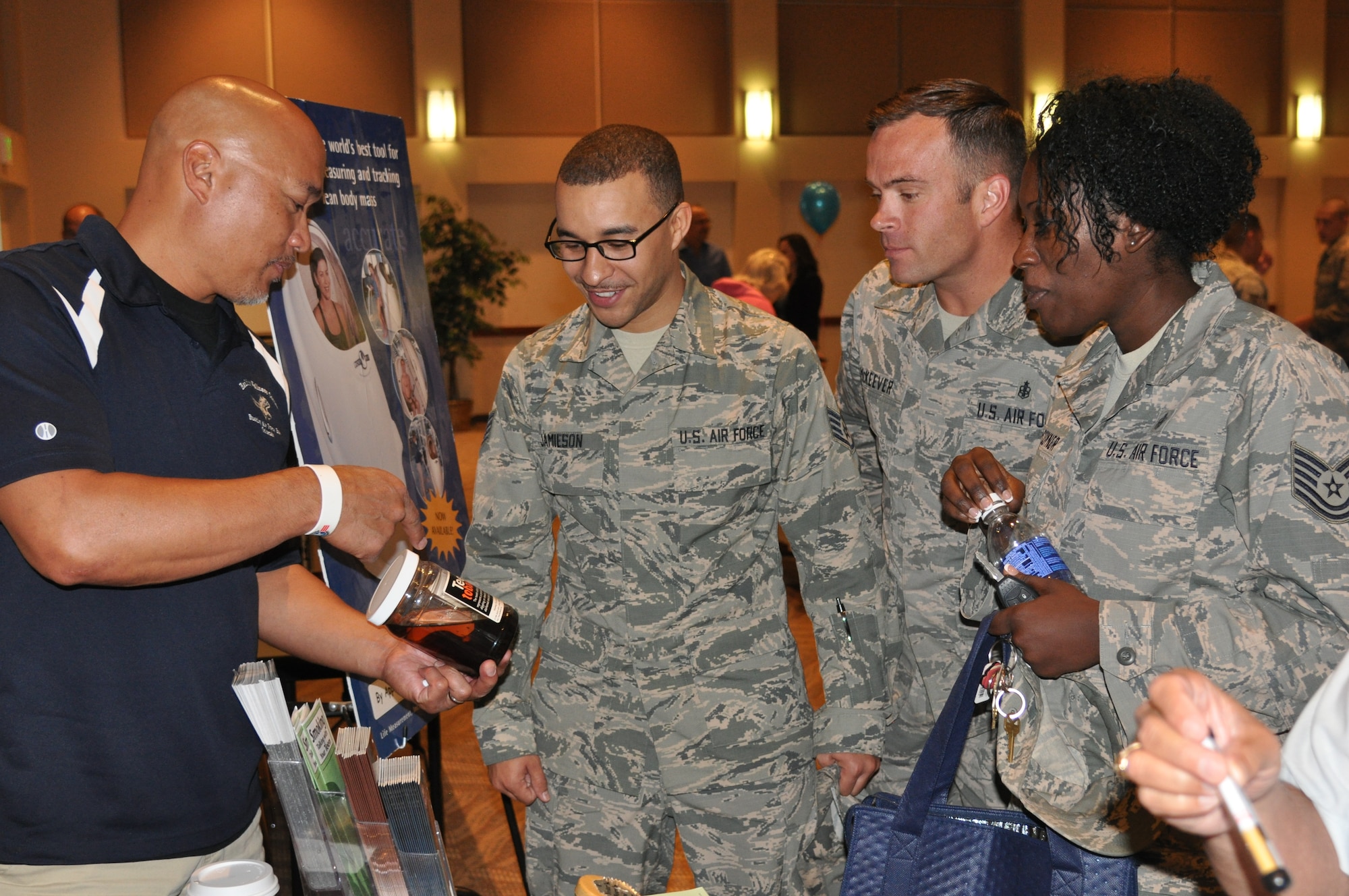 Alan Muriera, Buckley Health and Wellness Center health promotion manager and tobacco cessation coordinator, discusses the effects on teeth from chewing tobacco with Staff Sgt. Dominique Jamieson, 460th Medical Group NCO in charge of bioenvironmental engineering, Tech. Sgt. Jonathan McKeever, 460th MDG NCO in charge of dental services, and Tech. Sgt. Laquanya Mason-Coyner, 460th MDG mental health flight chief, during Team Buckley’s resource community expo Sept. 24, 2014, at the Leadership Development Center on Buckley Air Force Base, Colo. (U.S. Air Force photo by Tech. Sgt. Rob Hazelett/Released)