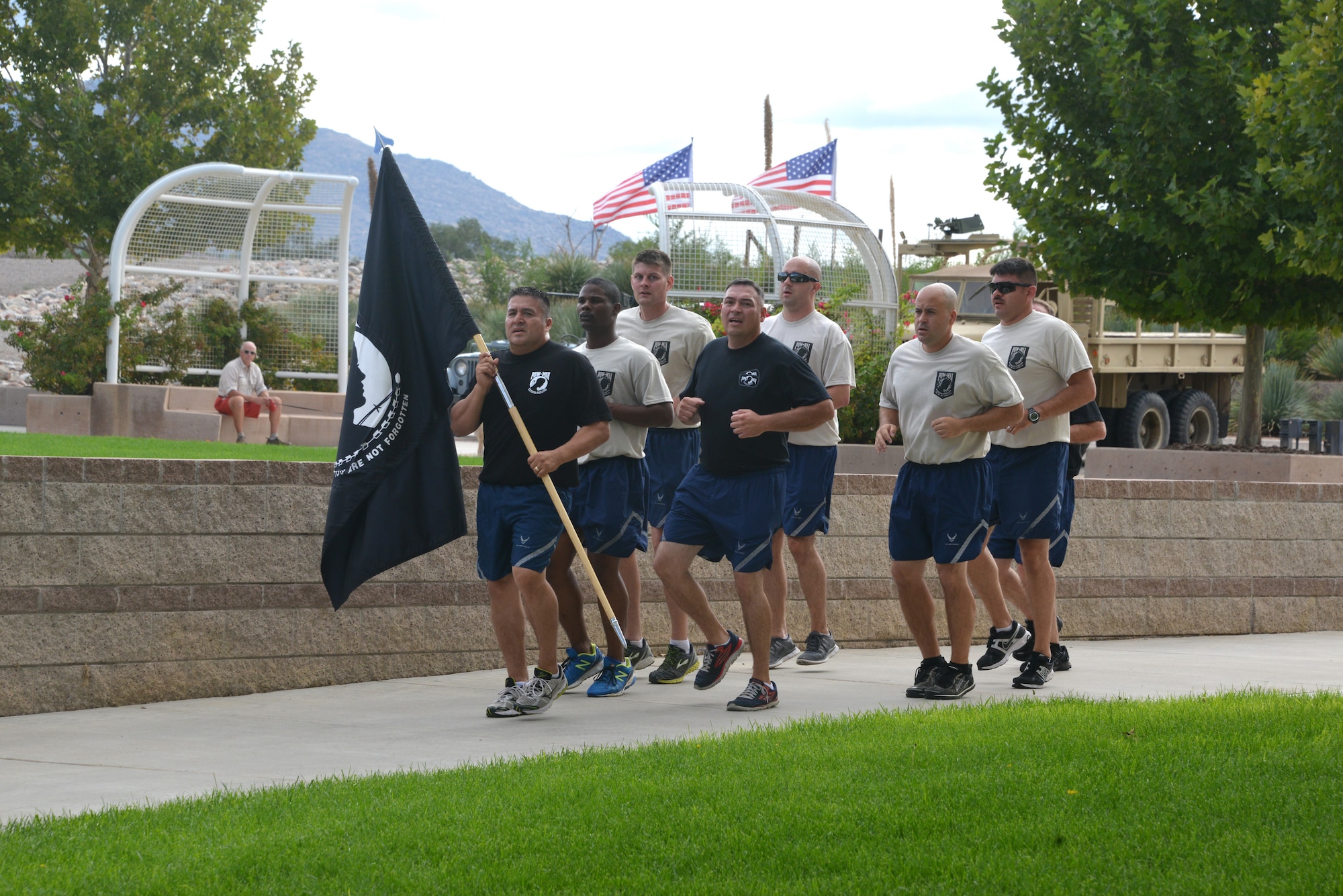 Kirtland Airmen run with the POW flag, ending a 24-hour vigil run at the POW MIA Recognition Day ceremony Sept. 19 at the New Mexico Veteran's Memorial Amphitheater. (Photo by Dennis Carlson)