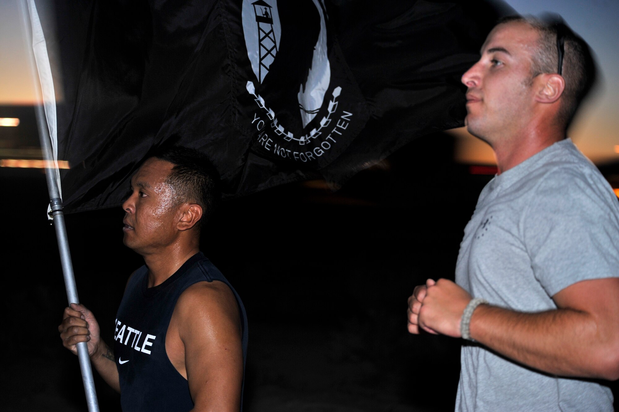 SSgt. Anthony Cabanillas, left, and SSgt. Gregory Gadsby, 99th Ground Combat Training Squadron integrated defense instructors, carry the POW/MIA flag during the 24-hour vigilance run Sept. 18, 2014, at Creech Air Force Base, Nevada. The vigilance run took place as part of POW/MIA Remembrance Week and honored more than 83,000 still unaccounted-for U.S. servicemembers. (U.S. Air Force photo by Airman 1st Class Christian Clausen/Released)