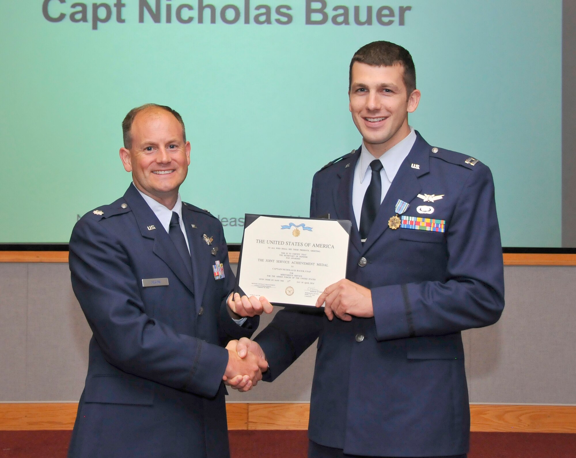 Capt. Nicholas Bauer (right), with the Arnold Engineering Development Complex (AEDC) Space and Missile Test Branch, receives the Joint Service Achievement Medal for Meritorious Service for the Armed Forces of the United States from Col. Jay Orson, the AEDC Space and Missile Test Branch director, on Aug. 28. The medal was awarded from the Department of Defense by Rear Adm. Deborah P. Haven with the U.S. Navy. She is the acting Defense Contract Management Agency International Commander. (Photo by Rick Goodfriend)