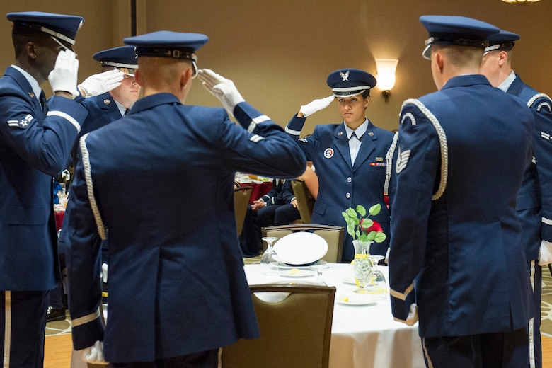Members of the 45th Space Wing Honor Guard salute the POW/MIA table during the Air Force Ball, an event hosted to celebrate the U.S. Air Force’s birthday, in Melbourne, Fla., Sept. 19, 2014. The POW/MIA table symbolizes that members of our profession of arms are still missing from our midst. (U.S. Air Force photo/Matthew Jurgens) (Released) 