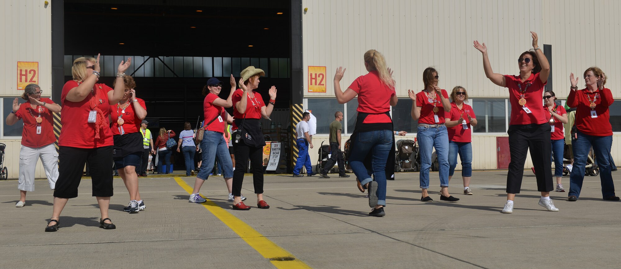 Members of the Ramstein Officers’ Spouses Club Bazaar Committee dance to music played at the Ramstein Welfare Bazaar on Ramstein Air Base, Germany, Sept. 20, 2014. The bazaar celebrated its 50th anniversary by hosting more than 28,000 patrons from around the Kaiserslautern Military Community and more than 160 vendors from around Europe. (U.S. Air Force photo/Senior Airman Holly Mansfield)