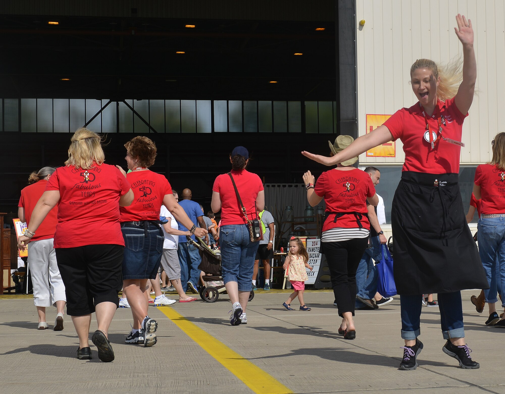 Members of the Ramstein Officers’ Spouses Club Bazaar Committee dance to music played at the Ramstein Welfare Bazaar on Ramstein Air Base, Germany, Sept. 20, 2014. The bazaar celebrated its 50th anniversary by hosting more than 28,000 patrons from around the Kaiserslautern Military Community and more than 160 vendors from around Europe. (U.S. Air Force photo/Senior Airman Holly Mansfield)