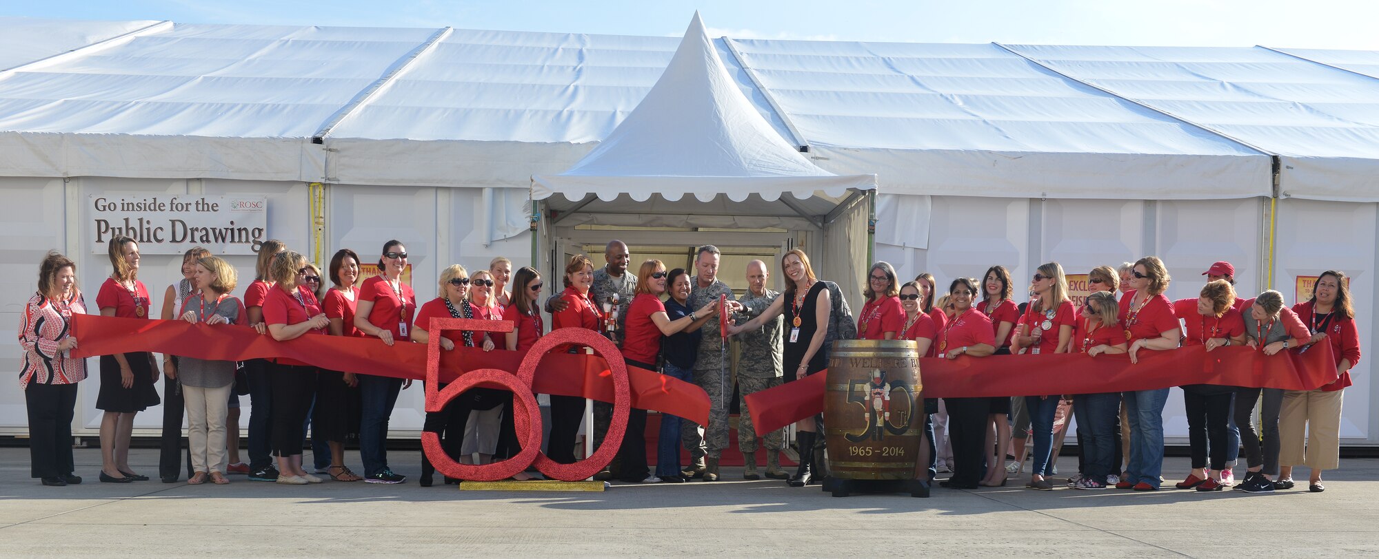 Brig. Gen. Patrick X. Mordente, 86th Airlift Wing commander, and key planners for the Ramstein Welfare Bazaar participate in a ribbon cutting to kick off the event on Ramstein Air Base, Germany, Sept. 20, 2014. The bazaar celebrated its 50th anniversary by hosting more than 28,000 patrons from around the Kaiserslautern Military Community and more than 160 vendors from around Europe. (U.S. Air Force photo/Senior Airman Holly Mansfield)