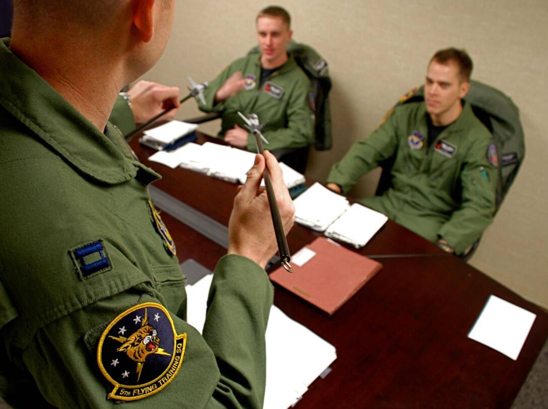 An instructor pilot with the 5th Flight Training Squadron, Vance Air Force Base, Oklahoma, discusses T-38 flying tactics with student pilots. 