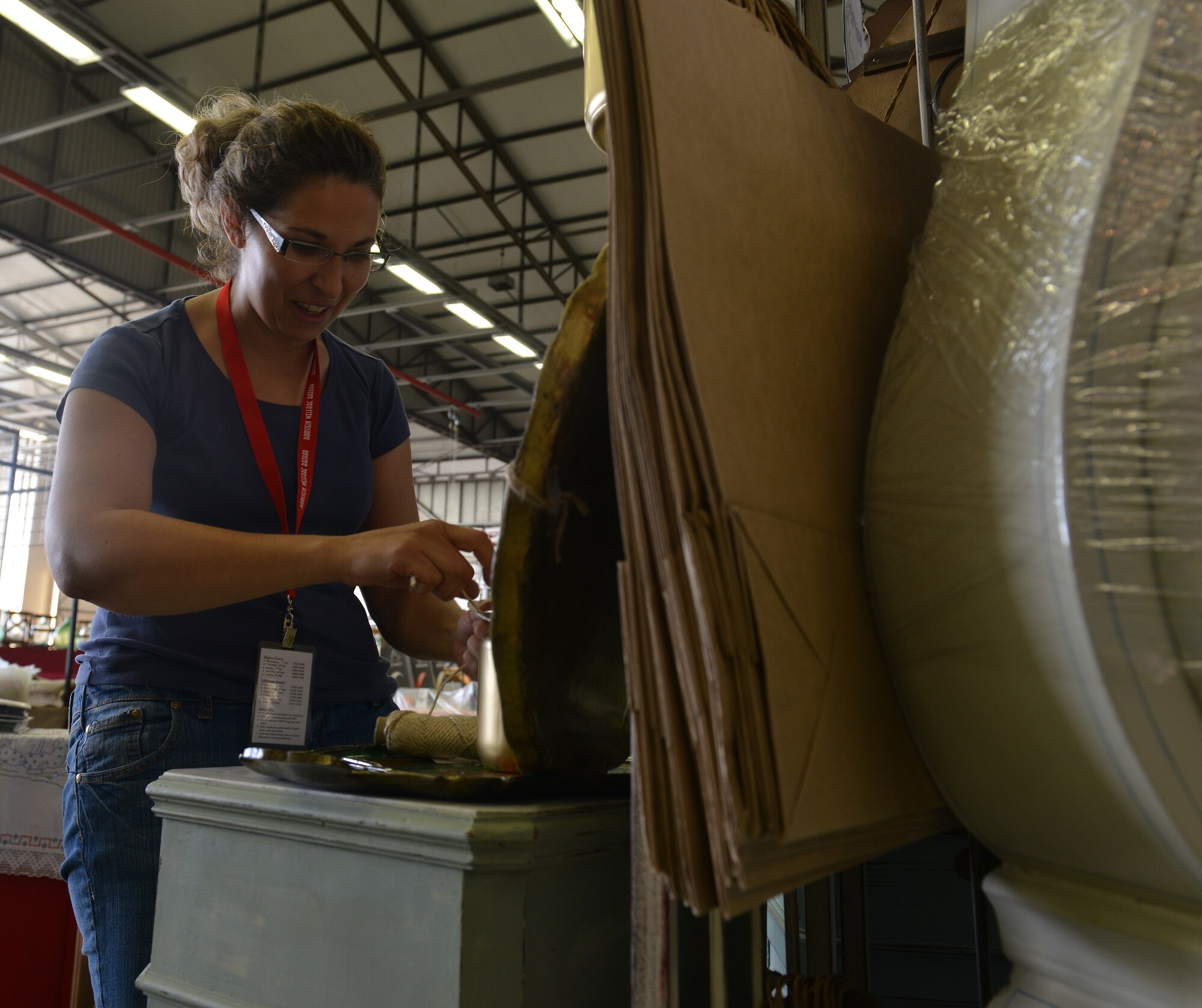 Andrea Noggle, vendor at the Ramstein Welfare Bazaar, prepares French painted vintage items before the start of the event on Ramstein Air Base, Germany, Sept. 20, 2014. Items varying from hand-made wooden clocks to Polish pottery were sold to more than 28,000 patrons over the span of the four-day 50th anniversary event. (U.S. Air Force photo/Senior Airman Holly Mansfield)