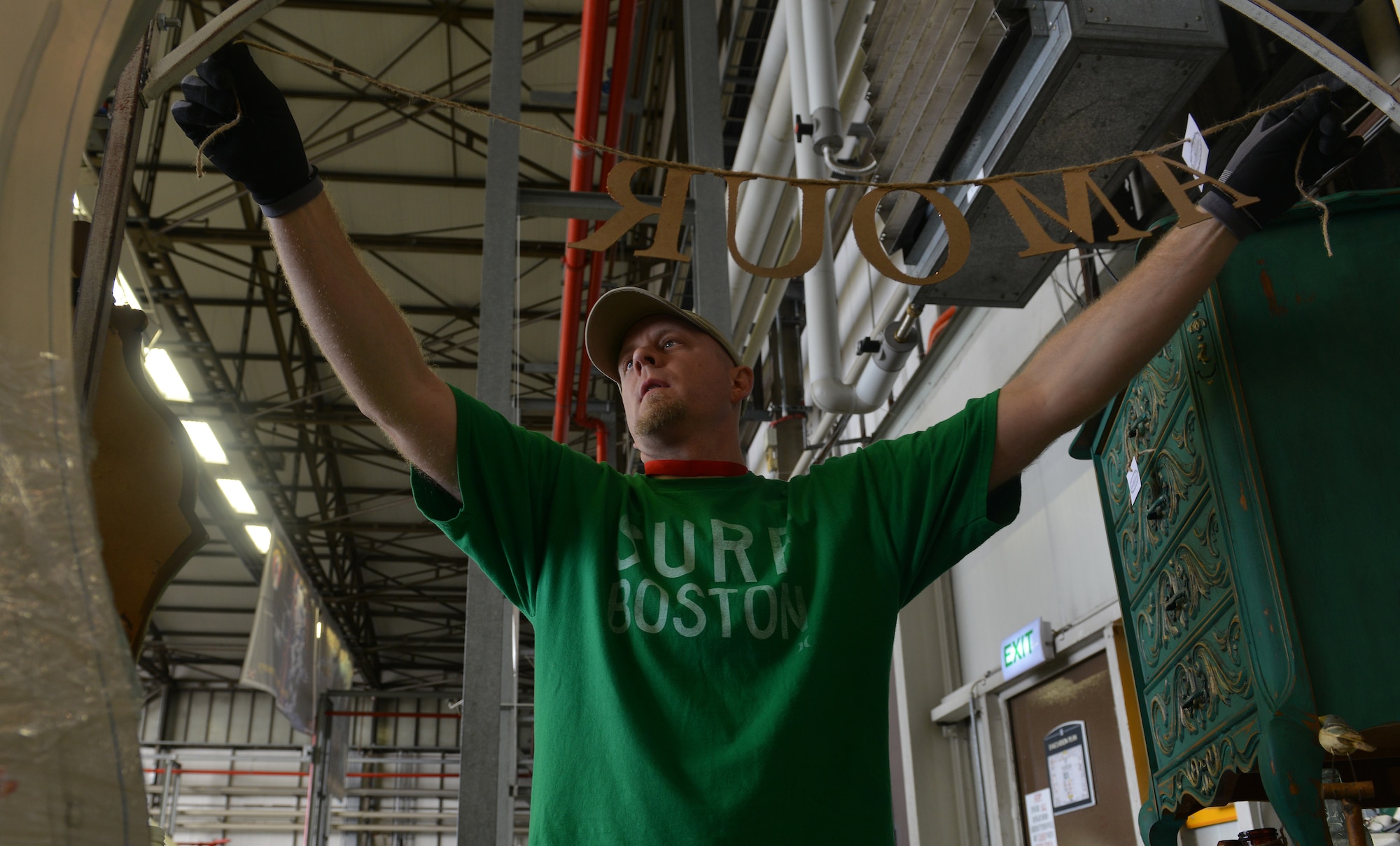Scott Noggle, vendor at the Ramstein Welfare Bazaar, hangs French painted vintage items before the start of the event on Ramstein Air Base, Germany, Sept. 20, 2014. Different items varying from hand-made wooden clocks to Polish pottery were sold to more than 28,000 patrons over the span of the four-day 50th anniversary event. (U.S. Air Force photo/Senior Airman Holly Mansfield)