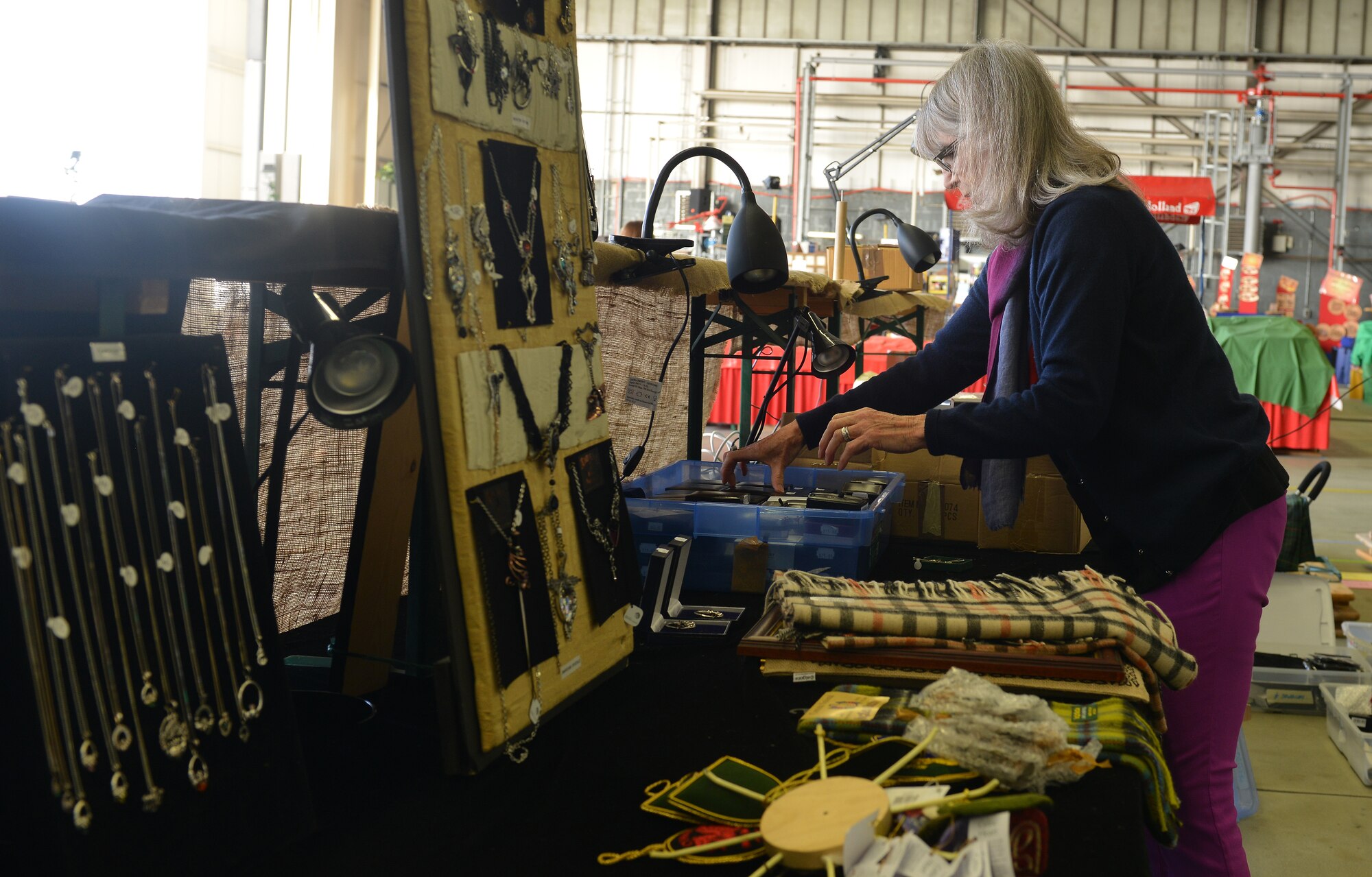 Anne Wormack, vendor at the Ramstein Welfare Bazaar, sets out Celtic jewelry before patrons come to shop on Ramstein Air Base, Germany, Sept. 20, 2014. Vendors from around Europe sold different trinkets to more than 28,000 patrons from around the Kaiserslautern Military Community. (U.S. Air Force photo/Senior Airman Holly Mansfield)