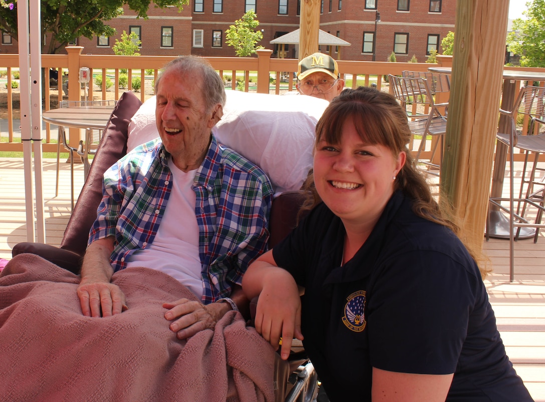 U.S. Air Force Senior Airman Sarah J. Carlson, instrumentalist with the 566th Air Force Band, visits with a veteran during the Air National Guard Band of the Midwest's annual training at the Tomah VA Medical Center Home, Tomah, Wisc., July 5, 2014. They performed jazz, rock and concert music for audiences in Illinois and Wisconsin as part of their community relations tour before a grand finale in Minnesota July 4. The annual concert series was the result of a year’s worth of training and practice, one that the band used to celebrate patriotism with communities across the Midwest. (Courtesy photo/Released)