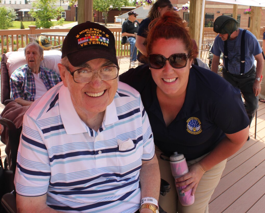 U.S. Air Force Tech. Sgt. Meredith G. Melvin, instrumentalist with the 566th Air Force Band, visits with a veteran during the Air National Guard Band of the Midwest's annual training at the Tomah VA Medical Center Home, Tomah, Wisc., July 5, 2014. They performed jazz, rock and concert music for audiences in Illinois and Wisconsin as part of their community relations tour before a grand finale in Minnesota July 4. The annual concert series was the result of a year’s worth of training and practice, one that the band used to celebrate patriotism with communities across the Midwest. (Courtesy photo/Released)