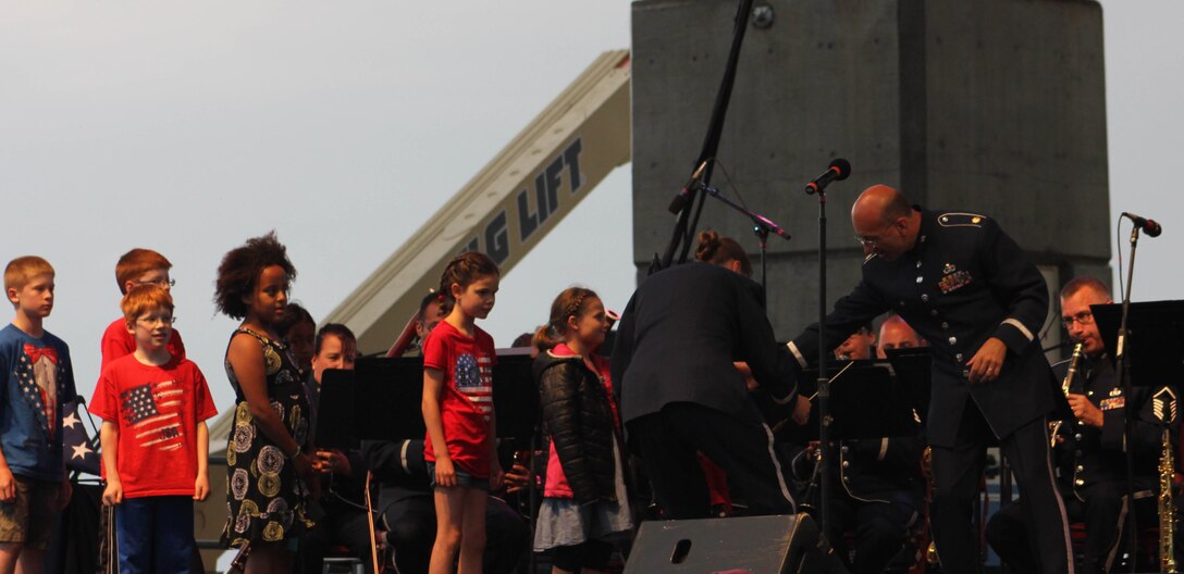 Children from the audience line up to help conduct the Air National Guard Band of the Midwest during annual training at the Bayfront Festival Park, Duluth, Minn., July 4, 2014. They performed jazz, rock and concert music for audiences in Illinois and Wisconsin as part of their community relations tour before a grand finale in Minnesota July 4. The annual concert series was the result of a year’s worth of training and practice, one that the band used to celebrate patriotism with communities across the Midwest. (Courtesy photo/Released)