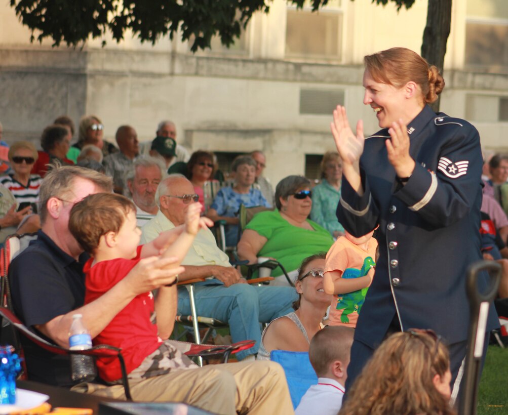 U.S. Air Force Staff Sgt. Sarah E. Kaiser, instrumentalist with the 566th Air Force Band, dances with the audience as the Air National Guard Band of the Midwest performs during annual training at the Grundy County Courtyard Lawn, Morris, Ill., June 29, 2014. They performed jazz, rock and concert music for audiences in Illinois and Wisconsin as part of their community relations tour before a grand finale in Minnesota July 4. The annual concert series was the result of a year’s worth of training and practice, one that the band used to celebrate patriotism with communities across the Midwest. (Courtesy photo/Released)