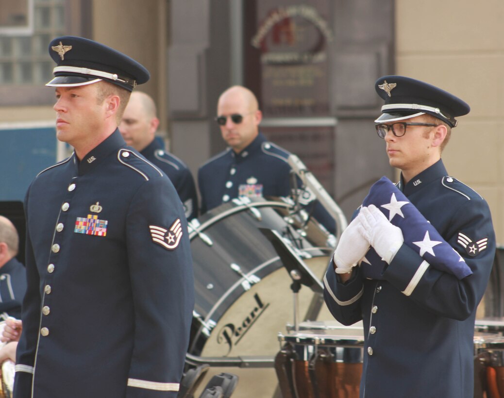 From left, U.S. Air Force Staff Sgt. Scott A. Parsons and Senior Airman Devin P. Larue, both instrumentalists with the 566th Air Force Band, conduct a flag-folding ceremony during the Air National Guard Band of the Midwest's annual training at the Grundy County Courtyard Lawn, Morris, Ill., June 29, 2014. They performed jazz, rock and concert music for audiences in Illinois and Wisconsin as part of their community relations tour before a grand finale in Minnesota July 4. The annual concert series was the result of a year’s worth of training and practice, one that the band used to celebrate patriotism with communities across the Midwest. (Courtesy photo/Released)