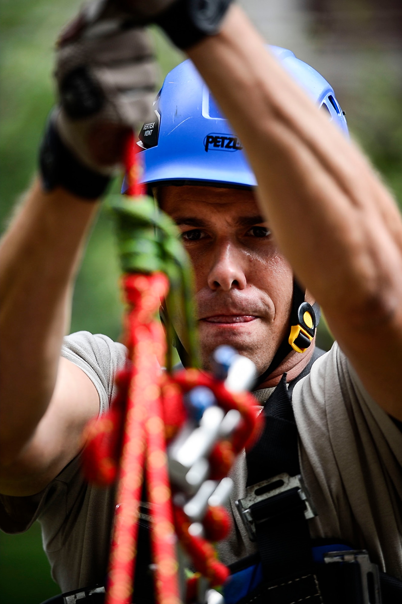 U.S. Air Force Senior Airman Thomas Stewart, 633rd Civil Engineer Squadron driver operator, fixes a system obstacle in a rope during training at Langley Air Force Base, Va., Sept. 17, 2014. The training, equips firefighters with the skills to perform high angle rescues. (U.S. Air Force photo by Senior Airman Kayla Newman/Released)
