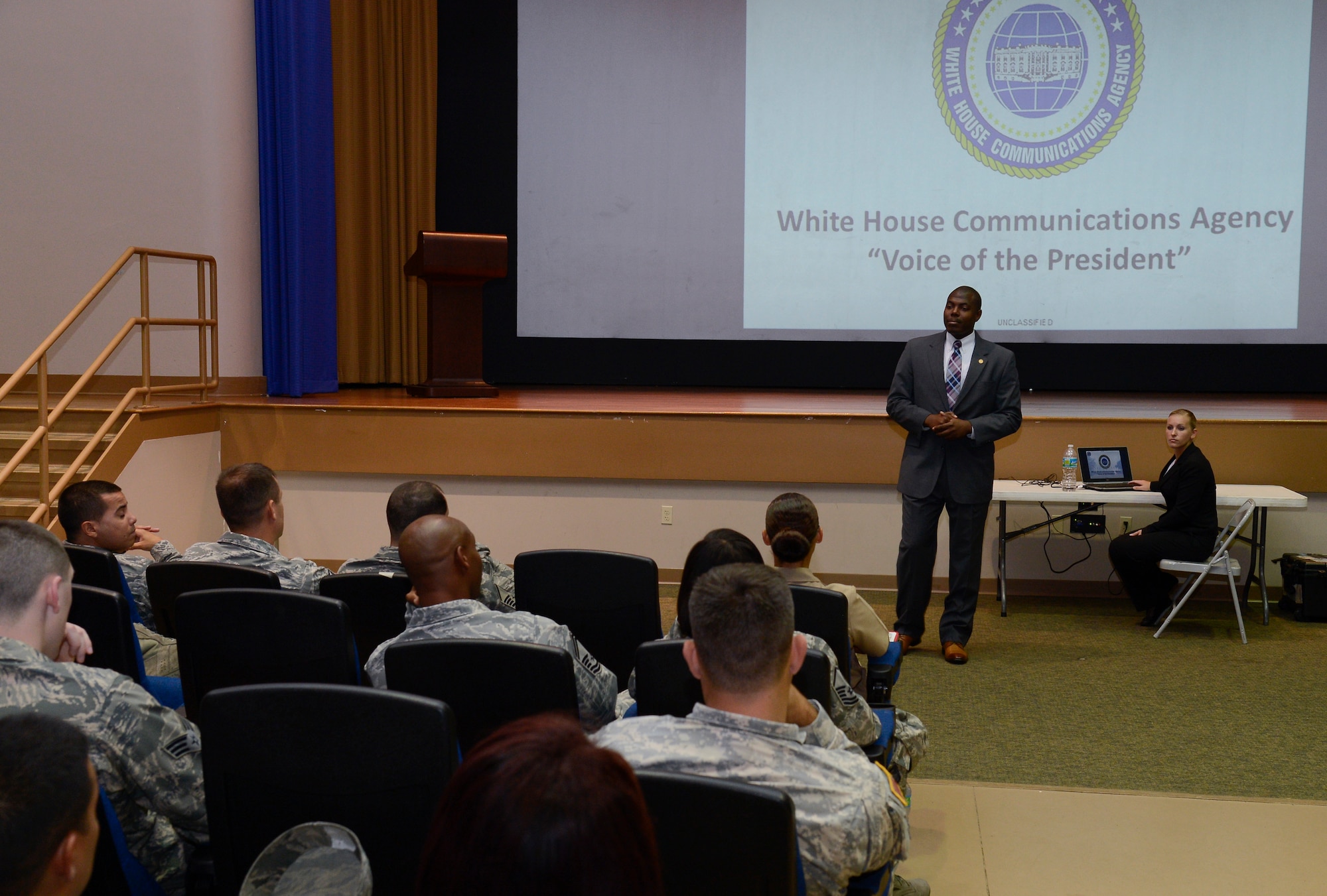 Staff Sgt. Willie Lee, White House Communications Agency Air Force lead recruiter, briefs members of Team MacDill at the base theater on MacDill Air Force Base, Fla., Sept. 23, 2014. The WHCA briefed service members on the requirements and duties of members applying for a staff position with WHCA. (U.S. Air Force photo by Senior Airman Shandresha Mitchell/Released)