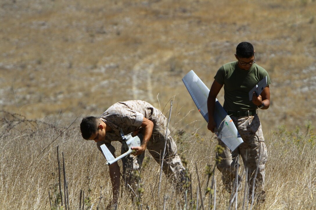 Lance Cpl. Anthony Galvan, 19, and Pfc. Brian Morales, 19, with 2nd Battalion, 5th Marine Regiment retrieve the RQ-11B Raven (small unmanned surveillance systems) after a landing, aboard Marine Corps Base Camp Pendleton, Calif., Sept. 8-19. Infantry and intelligence Marines with 1st Marine Division witnessed the capabilities of the aircraft firsthand during a two-week introduction course to the SUASS which is used to pervade timely reliable information. (USMC photo by Lance Cpl. Ashton C. Buckingham)