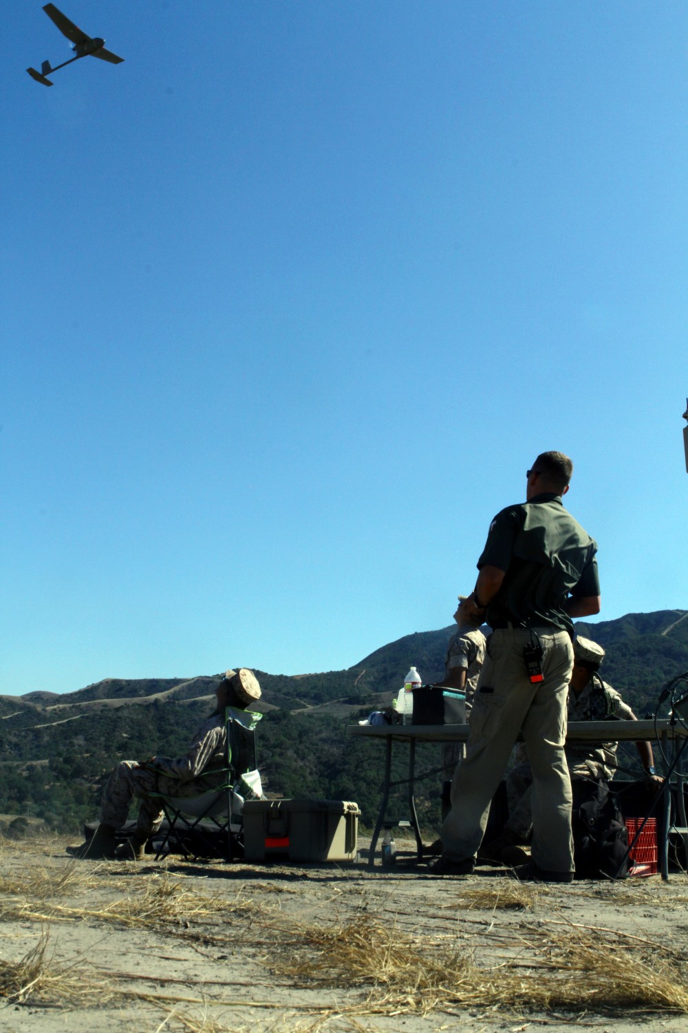 An instructor demonstrates low altitude approaches with the RQ-11B Raven (small unmanned surveillance systems) to his group, aboard Marine Corps Base Camp Pendleton, Calif., Sept. 8-19. Infantry and intelligence Marines with 1st Marine Division witnessed the capabilities of the aircraft firsthand during a two-week introduction course to the SUASS which is used to pervade timely reliable information. (USMC photo by Lance Cpl. Ashton C. Buckingham)