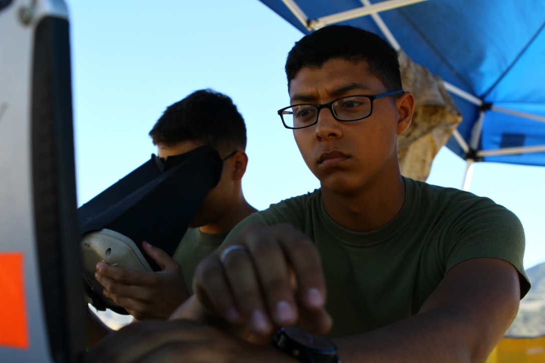 Lance Cpl. Anthony Galvan, 19, the vehicle operator (left) and Pfc. Brian Morales, 19, the mission operator (right) with 2nd Battalion, 5th Marine Regiment conduct practice flying the RQ-11B Raven (small unmanned surveillance systems), aboard Marine Corps Base Camp Pendleton, Calif., Sept. 8-19. Infantry and intelligence Marines with 1st Marine Division witnessed the capabilities of the aircraft firsthand during a two-week introduction course to the SUASS which is used to pervade timely reliable information. (USMC photo by Lance Cpl. Ashton C. Buckingham)