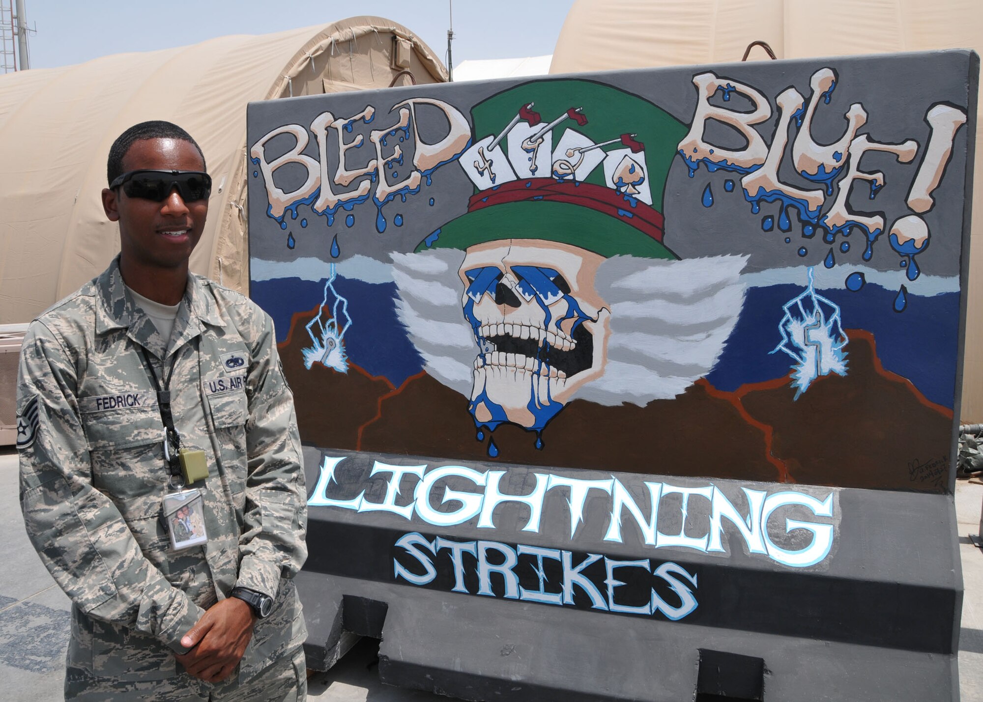 Air Force Staff Sgt. Quentin Fedrick designed and painted an art mural on a barrier located near the flightline at the 380th Air Expeditionary Wing at an undisclosed area in Southwest Asia, Aug. 21, 2014. (U.S. Air National Guard photo by Senior Master Sgt. Eric Peterson/Released)