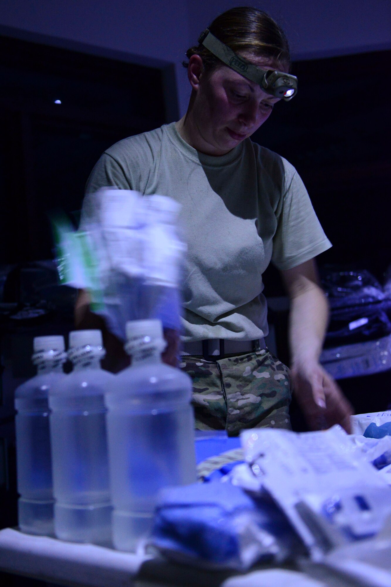 U.S. Air Force Staff Sgt. Vanessa Bates, 379th Expeditionary Medical Operations Squadron surgical technician, sets up medical supplies for a training exercise at Al Udeid Air Base, Qatar, Sept. 24, 2014. During the exercise the Airmen were tested on setting up an operating room and triage area with only; flash lights and head lamps. Bates is deployed from Langley Air Force Base, Virginia and hails from Pleasant City, Ohio. (U.S. Air Force photo by Staff Sgt. Ciara Wymbs)