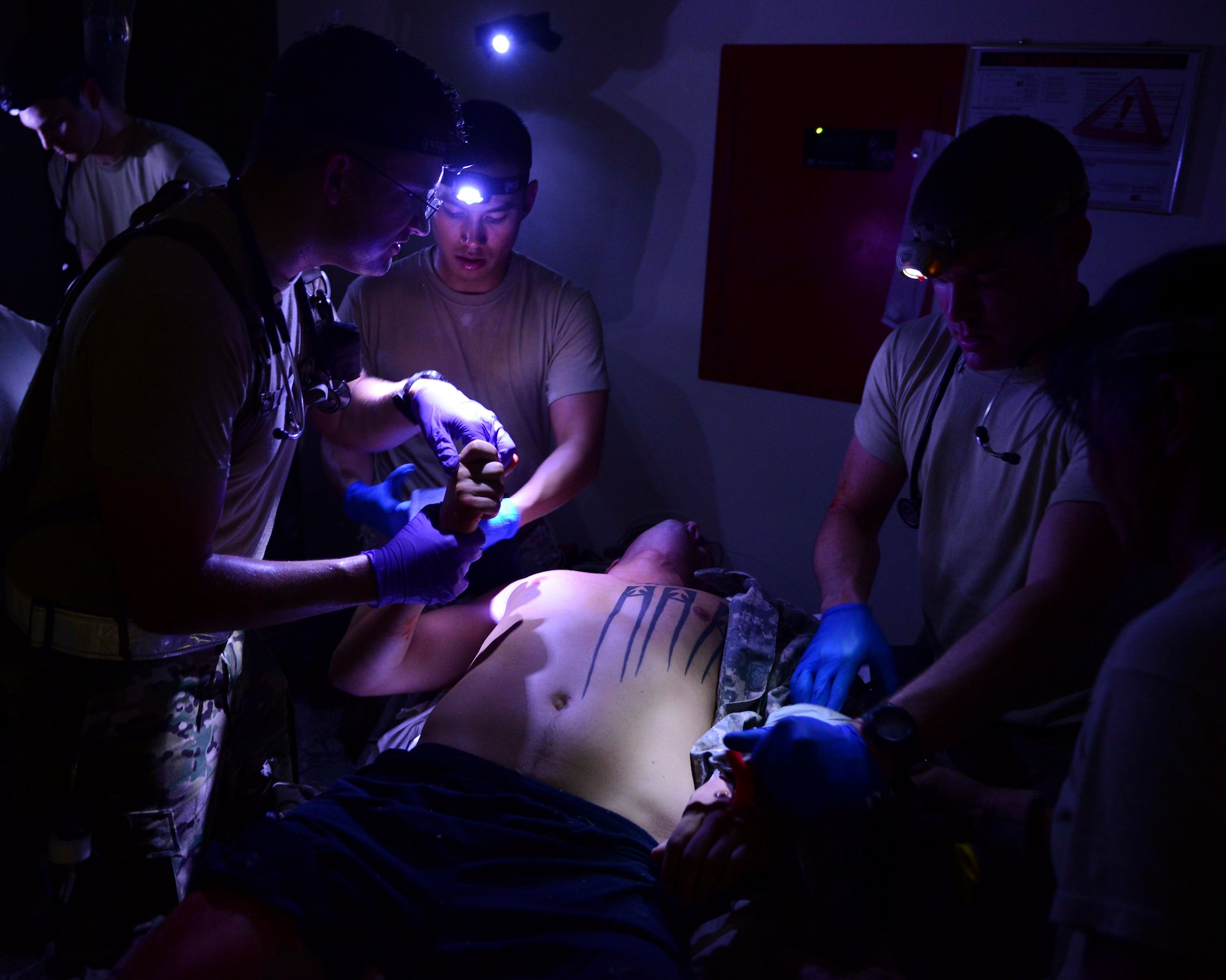 U.S. Air Force Airmen from the 379th Expeditionary Medical Group treat simulated casualties during an exercise at Al Udeid Air Base, Qatar, Sept. 24, 2014. The exercise was conducted to train Airmen on how to respond to the simulated receipt of casualties in a building of opportunity and darkness. (U.S. Air Force photo by Staff Sgt. Ciara Wymbs)