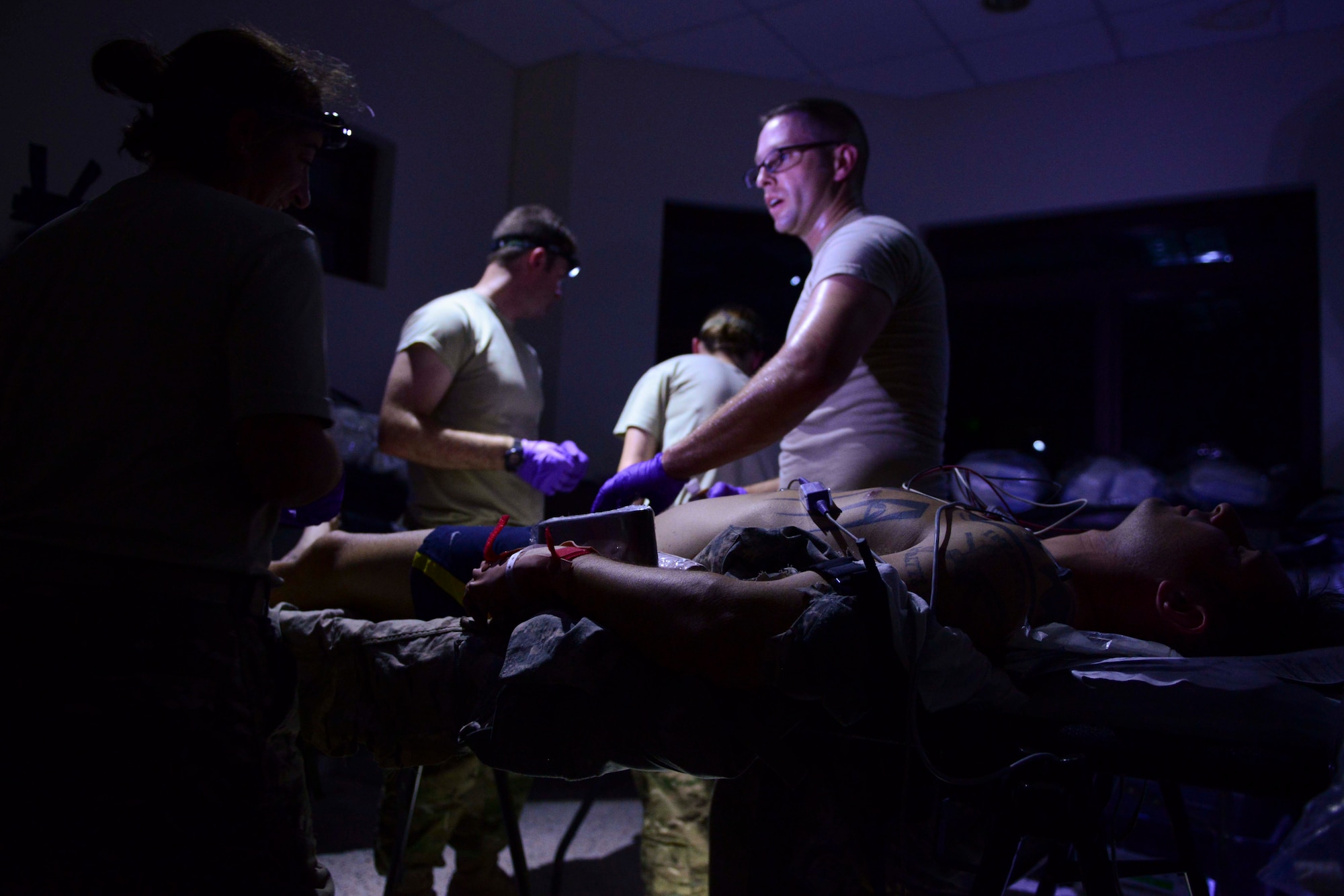 U.S. Air Force Airmen from the 379th Expeditionary Medical Group treat simulated casualties during an exercise at Al Udeid Air Base, Qatar, Sept. 24, 2014. During the exercise Airmen used skills to treat casualties with minimal light in an isolated area. (U.S. Air Force photo by Staff Sgt. Ciara Wymbs)