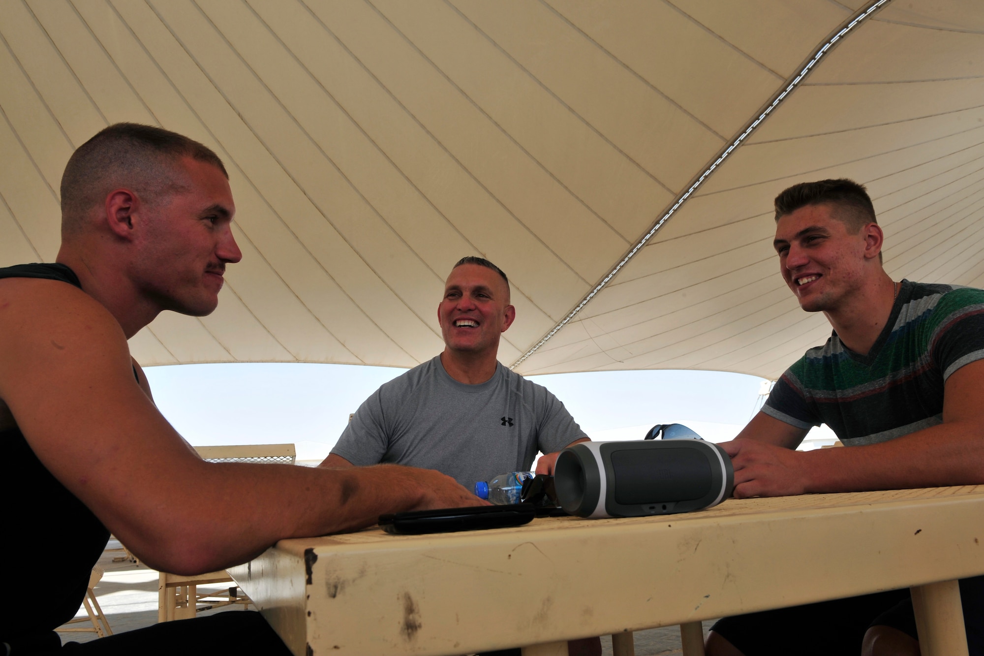 U.S. Air Force Staff Sgt. Matthew Dillon, left, 379th Expeditionary Aircraft Maintenance Squadron, Senior Master Sgt. Brian Dillon, middle, 340th Expeditionary Air Refueling Squadron boom operator, and Airman 1st Class Adam Dillon, right, 379th Expeditionary Aircraft Maintenance Squadron KC-135 Stratotanker  enjoy a conversation at Al Udeid Air Base, Qatar, Sept. 20, 2014. Brian Dillon and his two sons Matthew and Adam have more than 40 years of service together and are deployed together for the first time. The Dillon’s are deployed from the 190th Air Refueling Wing in Topeka, Kansas. Their hometown is Niagara Falls, New York. (U.S. Air Force photo by Senior Airman Colin Cates)