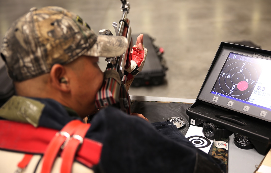 Capt. Chris McGleinnaiss from Kailua, Hawaii, checks his shot before aiming down range again during shooting practice for the Marine team, September 24, in preparation for the 2014 Warrior Games. The Marine team has been training since September 15 in order to build team cohesion and acclimate to the above 6,000 ft. altitude of Colorado Springs.  The Marine team is comprised of both active duty and veteran wounded, ill and injured Marines who are attached to or supported by the Wounded Warrior Regiment, the official unit of the Marine Corps charged with providing comprehensive non-medical recovery care to wounded, ill and injured Marines.  The Warrior Games are a Paralympic-style competition for more than 200 wounded, ill and injured service members and are taking place September 28 to October 5 at the Olympic Training Center in Colorado Springs, Colorado.  Follow the Marine team's progress at www.facebook.com/wwr.usmc.