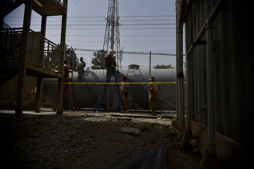 U.S. Air Force Airmen with the 455th Expeditionary Civil Engineer Squadron weld a fence at Bagram Airfield, Afghanistan Spet. 19, 2014.  The Airmen have been working on  a security project for several days. As Civil Engineer Airmen they are responsible for maintaining structures and utilities. (U.S. Air Force photo by Staff Sgt. Evelyn Chavez/Released)