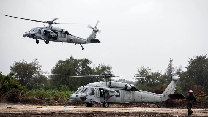 Two Navy MH-60S Seahawk helicopters with Helicopter Sea Combat Squadron 25, Helicopter Sea Combat Wing Pacific land on Echo Field, Tinian, Commonwealth of the Northern Marianas Islands, during the first day of Forager Fury III on Sept. 24, 2014. Echo Field is a 7,000 by 500 foot runway cleared by Marine Wing Support Squadron 171 heavy equipment operators. An estimated 1300 personnel are participating in FF III, which is a Marine Corps led exercise involving a full spectrum of fixed wing and rotary aircraft operations between Guam and Tinian. FF III began Sept. 24, and is scheduled to continue through Oct. 6.