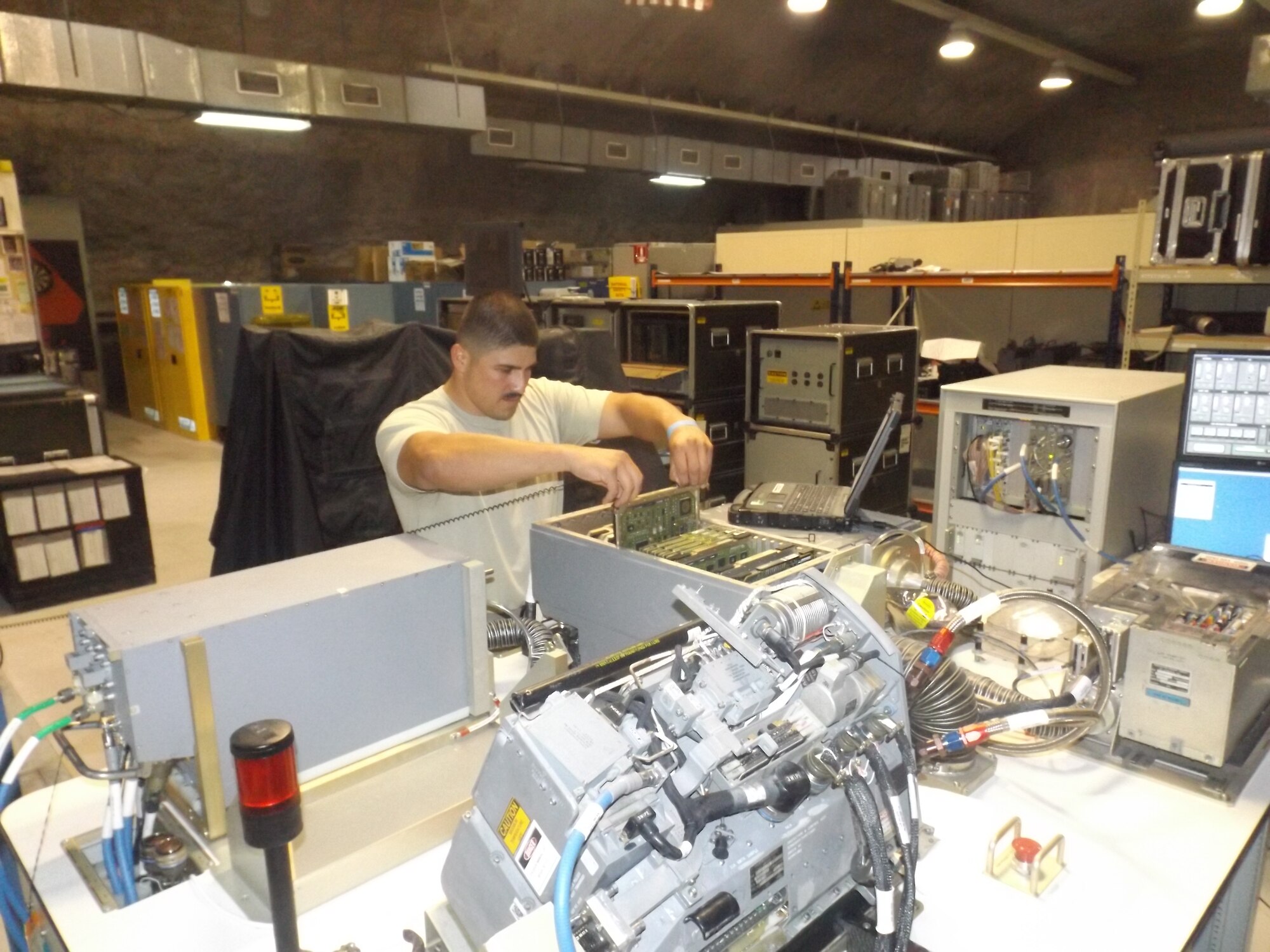 U.S. Air Force Senior Airman Ray Ramos, 379th Expeditionary Maintenance Squadron avionics flight member, removing a circuit card from a Common Radar Processor (CoRP) at Al Udeid Air Base, Qatar. Ramos is deployed from Dyess Air Force Base, Texas and hails from Fort Stockton, Texas. (Courtesy Photo)