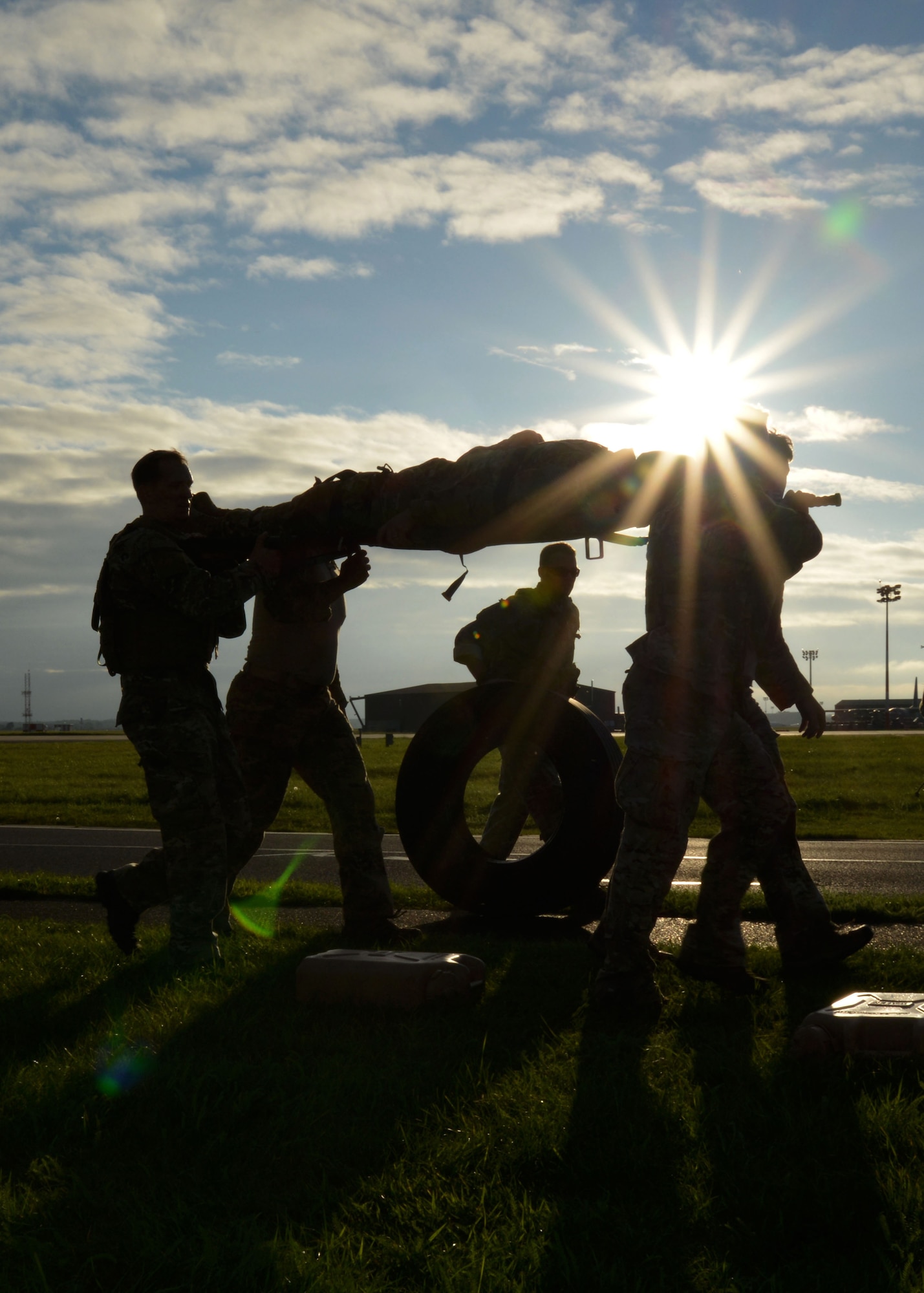 A team carries an “injured” teammate, jerry cans of water and tires to the next station Sept. 26, 2014, during the Monster Mash on RAF Mildenhall, England. The Monster Mash consisted of various events such as carrying an inflatable boat, marching with a 40-pound rucksack and a blind weapons assembly. A Monster Mash is a long-standing special tactics tradition which combines events designed to test strength, stamina and problem solving skills. (U.S. Air Force photo/Tech. Sgt. Stacia Zachary/Released)