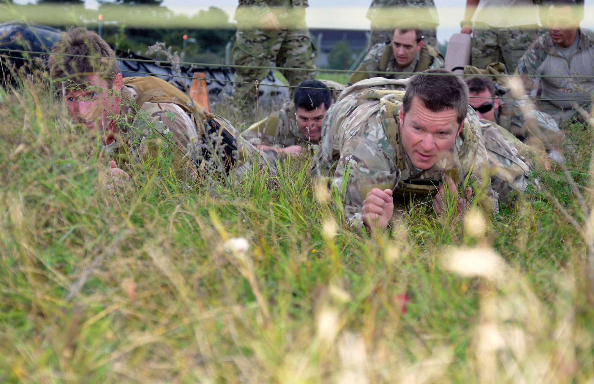U.S. Air Force Master Sgt. Tim Garlock, right, 321st Special Tactics Squadron combat controller, and U.S. Air Force Staff Sgt. Alan Abraham, 321st STS combat controller, navigate a high- and low-crawl station during the Monster Mash Sept. 26, 2014, on RAF Mildenhall, England. The Monster Mash consisted of various events such as carrying an inflatable boat, marching with a 40-pound rucksack and a blind weapons assembly. A Monster Mash is a long-standing special tactics tradition which combines events designed to test strength, stamina and problem solving skills. (U.S. Air Force photo/Tech. Sgt. Stacia Zachary/Released)
