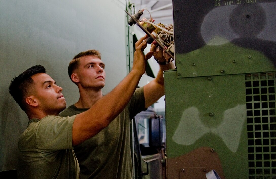 MARINE CORPS AIR STATION KANEOHE BAY - Lance Cpl. Gerber Portillo (left) and Lance Cpl. Jonathan Moore, both unmanned aerial vehicle technicians with Marine Unmanned Aerial Vehicle Squadron 3, start a generator in Hangar 102, Sept. 24, 2014. (U.S. Marine Corps photo by Kristen Wong)