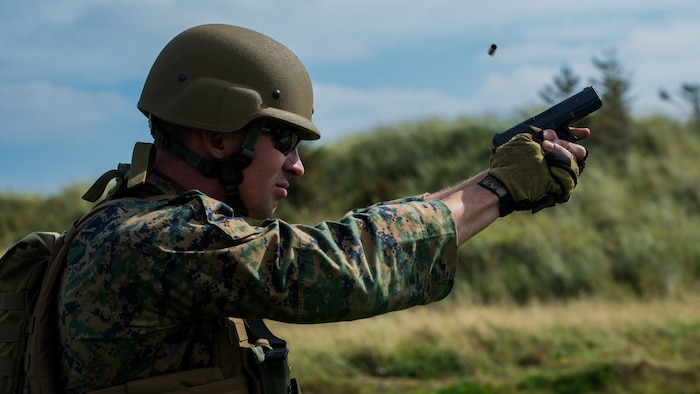 Sgt. Devin Hughes, a member of the Marine Corps Shooting Team, fires a round at a target during the Royal Marines Operational Shooting Competition at Altcar Range near Hightown, England, Sept. 8, 2014. The U.S. Marine Corps team dominated the pistol competitions, taking first place by more than 1,000 points. (U.S. Marine Corps photo by Cpl. Cameron Storm/Released)
