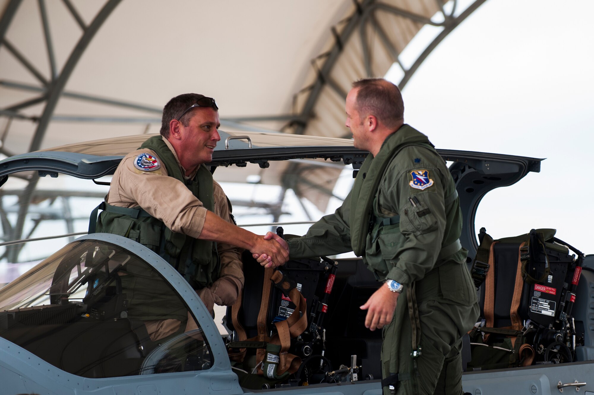 Chris Carlson, left, Sierra Nevada Corporation senior pilot, shakes hands with Lt. Col. Jeffrey Hogan, Afghan A-29 Light Air Support training unit commander, after landing an A-29 Super Tucano for its first arrival Sept. 26, 2014, at Moody Air Force Base, Ga. Moody was selected for the A-29 LAS training mission to train a total of 30 Afghan pilots and 90 Afghan maintainers over the next four years. (U.S. Air Force photo/Airman 1st Class Dillian Bamman) 