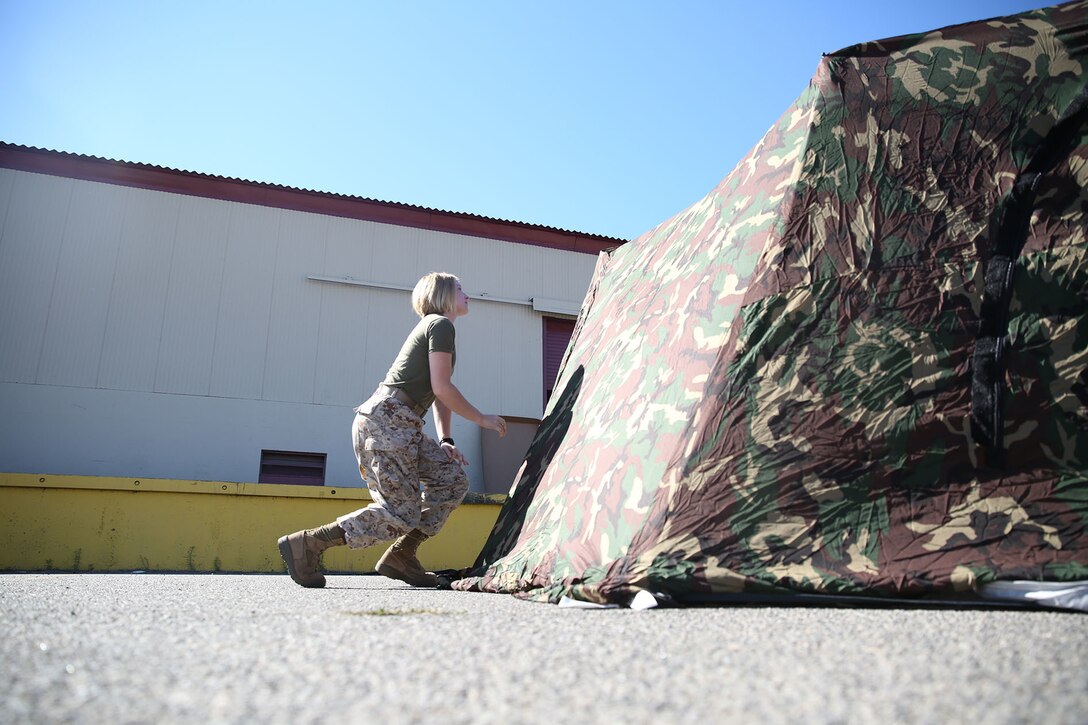 Private Sarah Trull, a fiscal clerk with Marine Air Group 39, puts together an Arctic shelter Aug. 29, 2014, aboard Camp Pendleton, California. The system is an ultra-lightweight, rapidly deployable shelter that offers military forces the necessary infrastructure to operate in austere cold-weather locations. The system is being used for training exercises in Bridgeport, California, and is slated to be integrated into exercises early next year. (U.S. Marine Corps photo by Sgt. Laura Gauna/released)