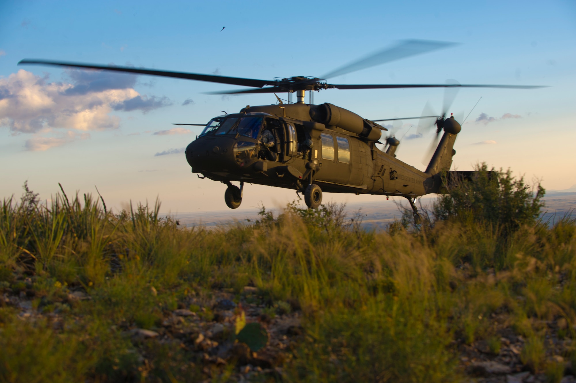 A U.S. Army UH-60M Black Hawk Helicopter hovers above a cliff during a training exercise at Holloman Air Force Base, N.M, 25 Sept. Soldiers from the 101st Airborne Division use the Holloman and White Sands Missile Range training ranges to conduct a Hostile Environment Medical Training Course, designed specifically for Close Protection Operations during deployments to high threat regions throughout the world. (U.S. Air Force photo by Airman 1st Class Chase Cannon/ Released)