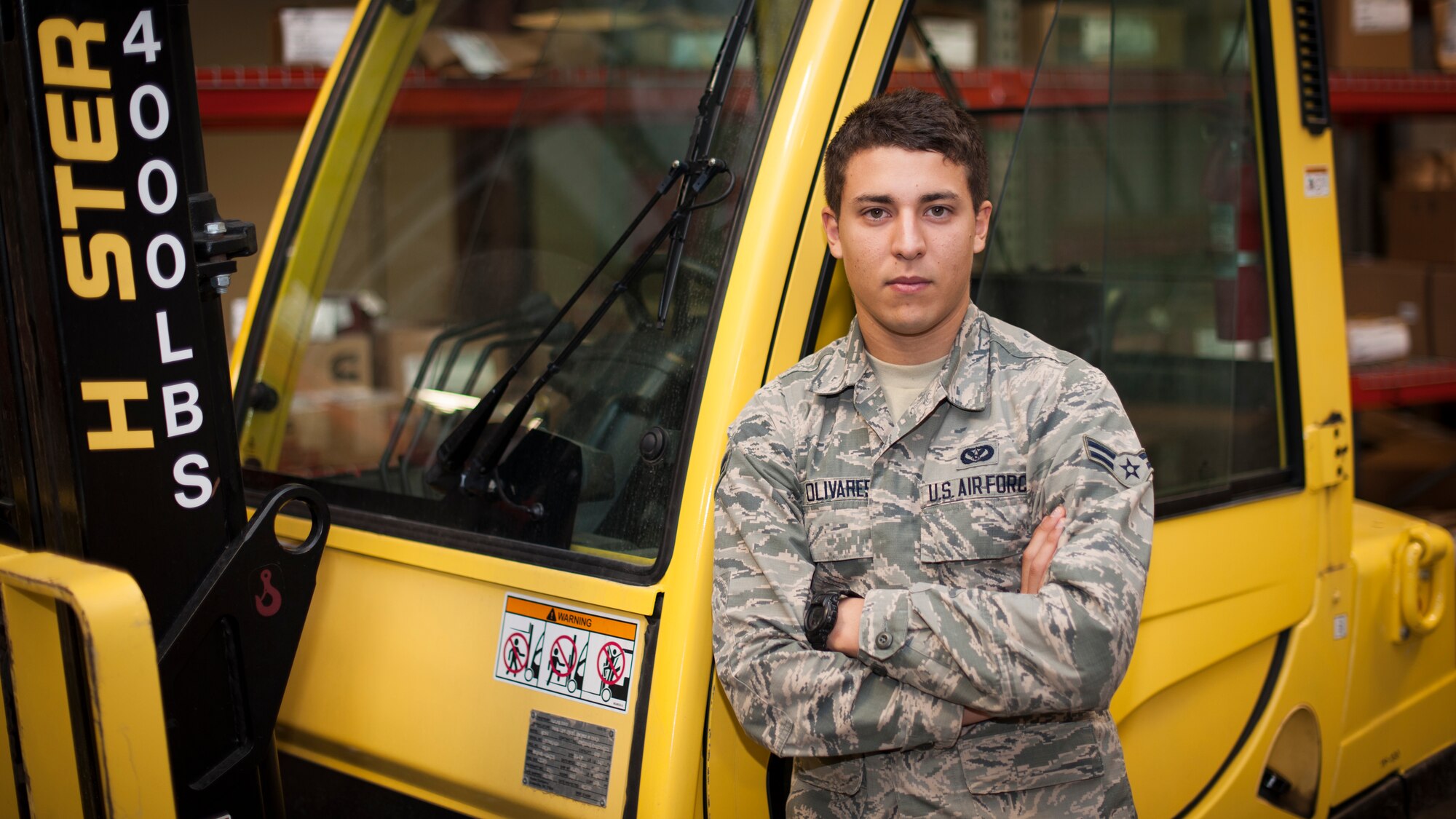 Airman 1st Class Jonathan Olivares, 49th Civil Engineer Squadron operations flight personnel, poses in front of a fork lift that is regularly used while procuring and managing repair materials at Holloman Air Force Base, N.M., Sept. 26. Olivares and the operations flight personnel are the central hub to assist facility managers when repair items or emergencies arise. These airmen work to ensure the right equipment and supplies are ordered, stocked and available for any facility emergency. (U.S. Air Force photo by Airman 1st Class Aaron Montoya / Released)