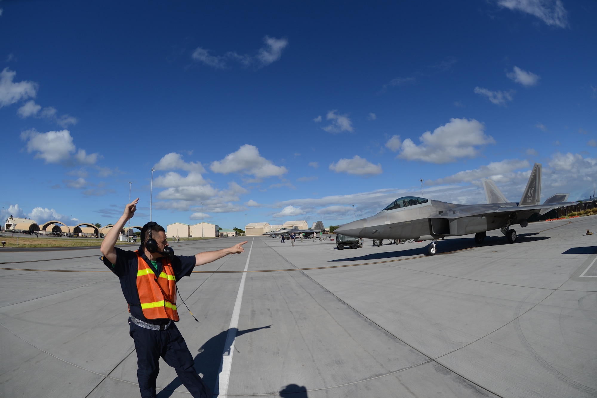 Staff Sgt. Michael Campbell, 477th Maintenance Squadron F-22 crew chief, signals to 302nd Fighter Squadron F-22 pilot Maj. Ryan Pelkola that he is clear to taxi during the 477th Fighter Group’s first ever group-wide off station annual tour at Joint Base Pearl Harbor Hickam, Hawaii Sept 6, 2014. (U.S. Air Force photo/Tech. Sgt. Dana Rosso)

