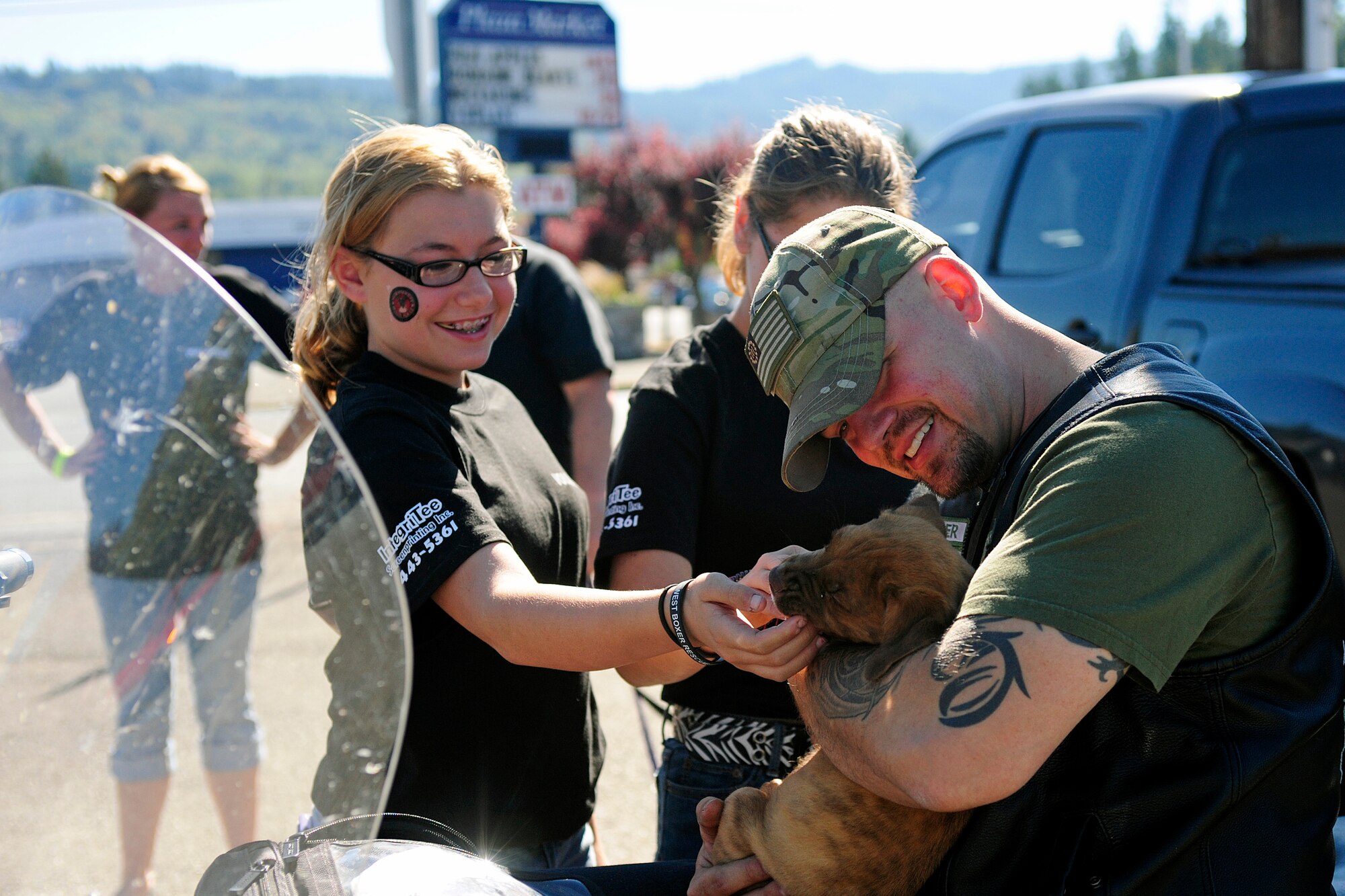 Tech. Sgt. Kevin Beers, 446th Security Forces Squadron combat arms instructor, plays with a rescued boxer puppy Sept. 20, 2014, at Bruno’s Family Restaurant in Eatonville, Wash. The Northwest Boxer Rescue relies solely on volunteers and donations to manage and care for the homeless dogs. (U. S. Air Force photo/Senior Airman Rebecca Blossom)