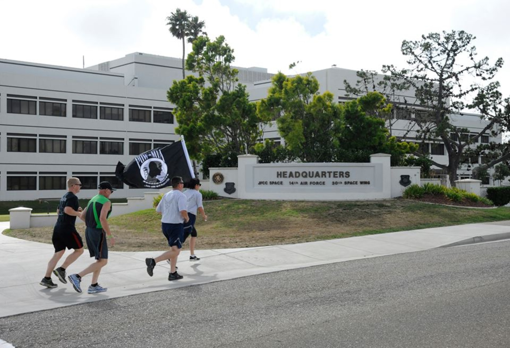 Members of Team-V participate in a remembrance run while carrying a POW/MIA flag, Sept. 18, 2014, Vandenberg Air Force Base, Calif. The remembrance run was one of the events held during National Prisoner of War and Missing in Action Recognition Day. (U.S. Air Force Photo by Airman Robert J. Volio/Released)
