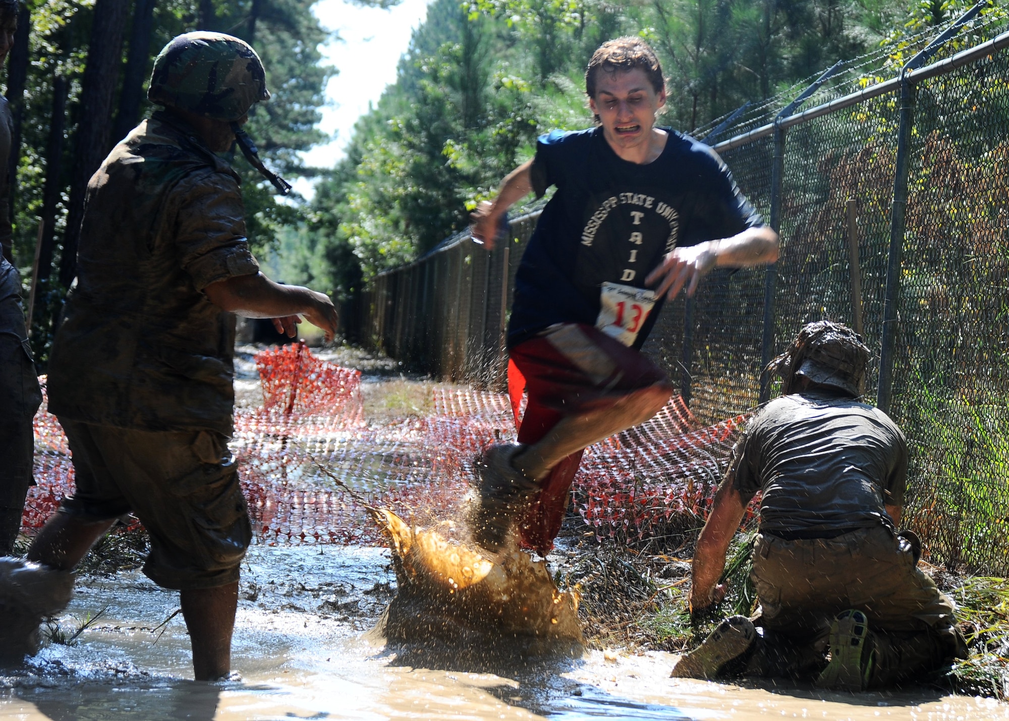 A Mississippi State University student attempts to avoid the wrath of two “zombies” at the second annual Zombie Run on Columbus Air Force Base, Mississippi Sept. 20. Participants ran along a five- kilometer muddy track through many obstacles, while trying to avoid the zombies on the path who tried to steal their flags. (U.S. Air Force photo/Airman John Day)