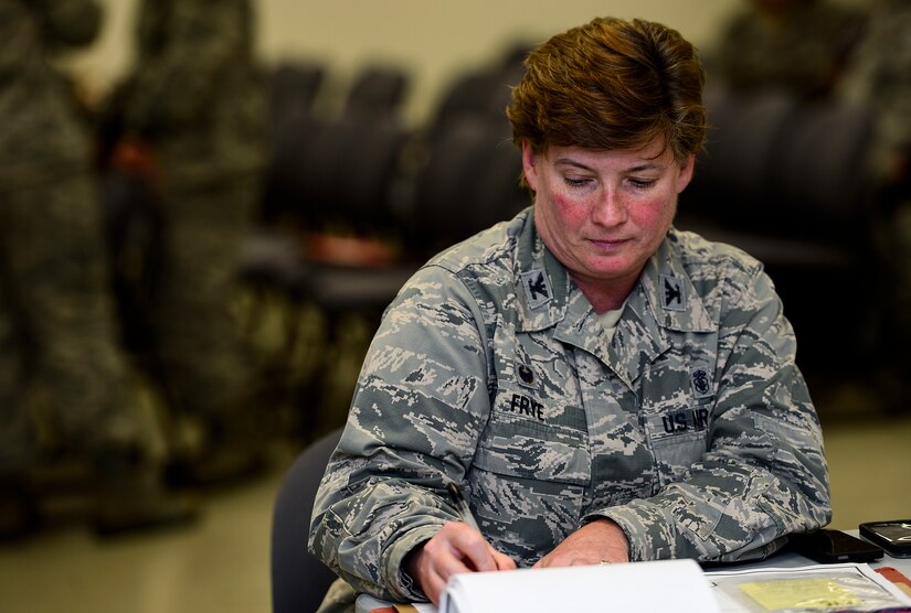 U.S. Air Force Col. Joann Frye, 633 Inpatient Operations Squadron commander, signs deployment paperwork at Langley Air Force Base, Va., Sept. 24, 2014. U.S. Air Force Airmen are deploying to West Africa to deliver and build the Air Force’s Expeditionary Medical Support System, a modular medical treatment platform and train healthcare workers in its operation. (U.S. Air Force photo by Senior Airman Kayla Newman/Released)