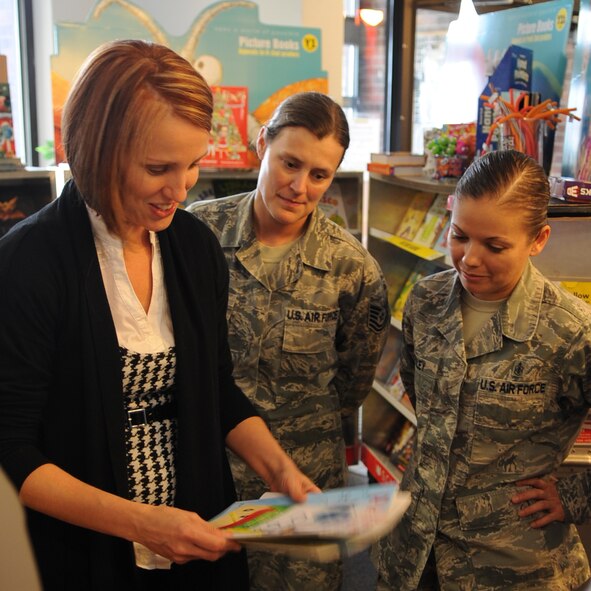 Mrs. Brandy Granger, left, 7th Maintenance Group commander’s secretary, shows U.S. Air Force Tech. Sgt. Josee McVadon, center, 7th Medical Operations Squadron physical therapy noncommissioned officer in charge, and Tech. Sgt. Valarie Risley, 7th Aerospace Medicine Squadron dental technician, how to scan and take payments for books during a book fair Sept. 23, 2014, in the Child Development Center (CDC) at Dyess Air Force Base, Texas. The book fair was hosted by the CDC, Scholastic and Parent Advisory Board. (U.S. Air Force photo by Senior Airman Shannon Hall/Released)