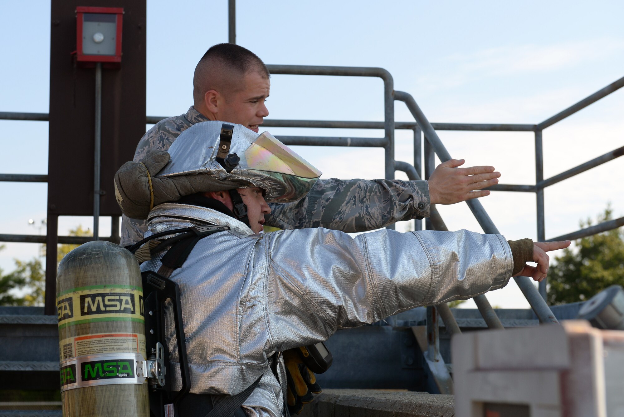 Michael Johnson, 375th Civil Engineering Squadron firefighter and Tech. Sgt. Daniel Singleton, a 375th Air Mobility Wing Inspection Team member, clarify the location of a simulated leaking fuel valve at Scott Air Force Base, Ill., Sept. 25, 2014. The 126th Air National Guard’s fuel tanks had a simulated leaking valve. Under a ticking clock, 375 CES, bioenvironmental, security forces, and other base resources converged to quickly mitigate the problem. The WIT observed the actions of the participating players and suggested the players went through the scenario just as they would do in real life to get the most out of the exercise. (U.S. Air Force photo by Airman 1st Class Erica Crossen)