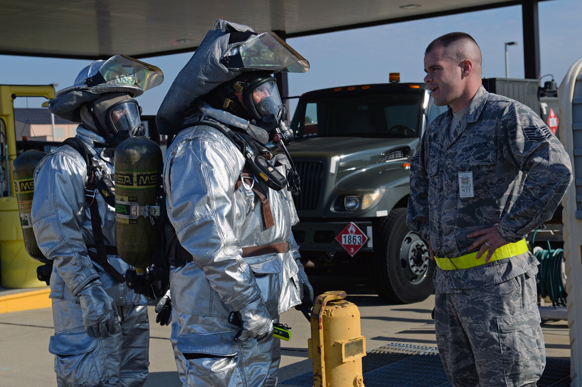 William Johnson, 375th Civil Engineering Squadron station captain, and Staff Sgt. Eric Butler, firefighter, exchange strategies they would use to mitigate a simulated fuel spill with Tech. Sgt. Daniel Singleton, a 375th Air Mobility Wing Inspection Team member at Scott Air Force Base, Ill., Sept. 25, 2014. The 126th Air National Guard’s fuel tanks had a simulated leaking valve. Under a ticking clock, 375 CES, bioenvironmental, security forces, and other base resources converged to quickly mitigate the problem. The WIT observed the actions of the participating players and suggested the players went through the scenario just as they would do in real life to get the most out of the exercise. (U.S. Air Force photo by Airman 1st Class Erica Crossen)
