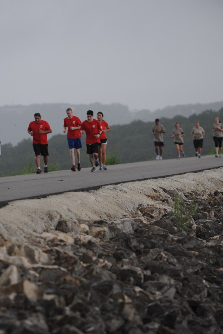 Teams run across the Canyon Lake dam following a 22-mile bike ride for the Rambler 120 Sept. 20 at Joint Base San Antonio Recreation Area at Canyon Lake. The run portion was 6 miles long and once completed the participants rowed 2 miles in boats to the finish line where they were greeted by Brig. Gen. Bob LaBrutta, 502nd Air Base Wing and Joint Base San Antonio commander. (U.S. Air Force photo by Senior Airman Krystal Jeffers/Released)