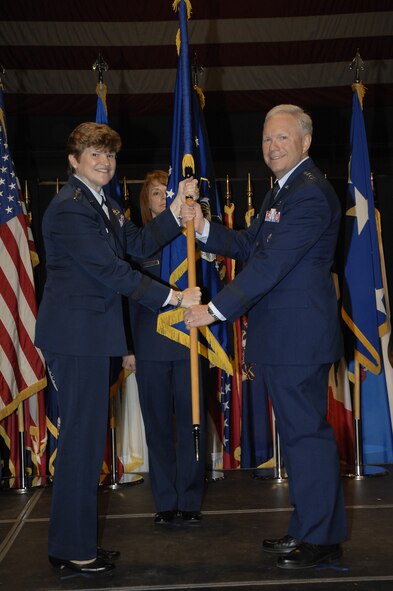 Gen. Janet Wolfenbarger, Air Force Materiel Command commander, passes the Air Force Life Cycle Management Center flag to Lt. Gen. John F. Thompson in a ceremony at the National Museum of the United States Air Force Sept. 26.  Thompson will officially take command of AFLCMC Oct. 2.  (Air Force photo by Al Bright)