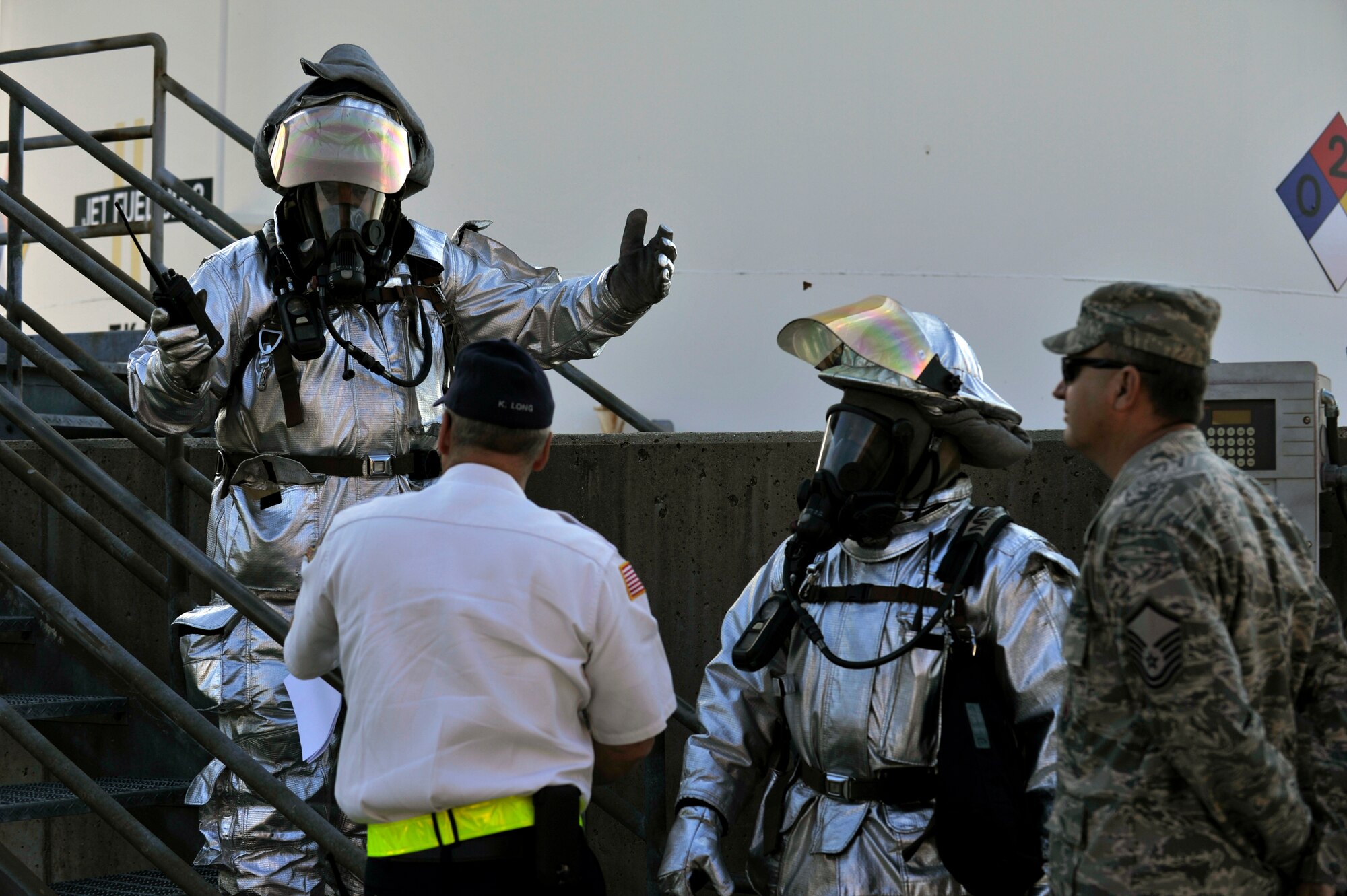 Firefighters from the 375th Civil Engineering Squadron work out a plan to deal with a simulated fuel spill at Scott Air Force Base, Ill., Sept. 25, 2014. The 126th Air National Guard’s fuel tanks had a simulated leaking valve. Under a ticking clock, 375 CES, bioenvironmental, security forces, and other base resources converged to quickly mitigate the problem. The Wing Inspection Team observed the actions of the participating players and suggested the players went through the scenario just as they would do in real life to get the most out of the exercise. (U.S. Air Force photo by Airman 1st Class Erica Crossen)
